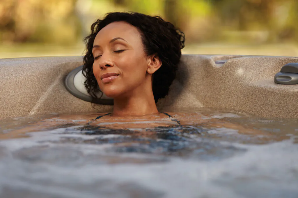 Mulher negra dentro de um SPA de hidromassagem.
